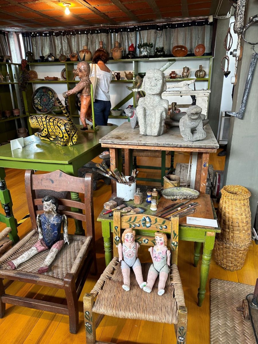 A photograph of Diego Rivera’s studio filled with furniture, dolls and pre-colonials objects