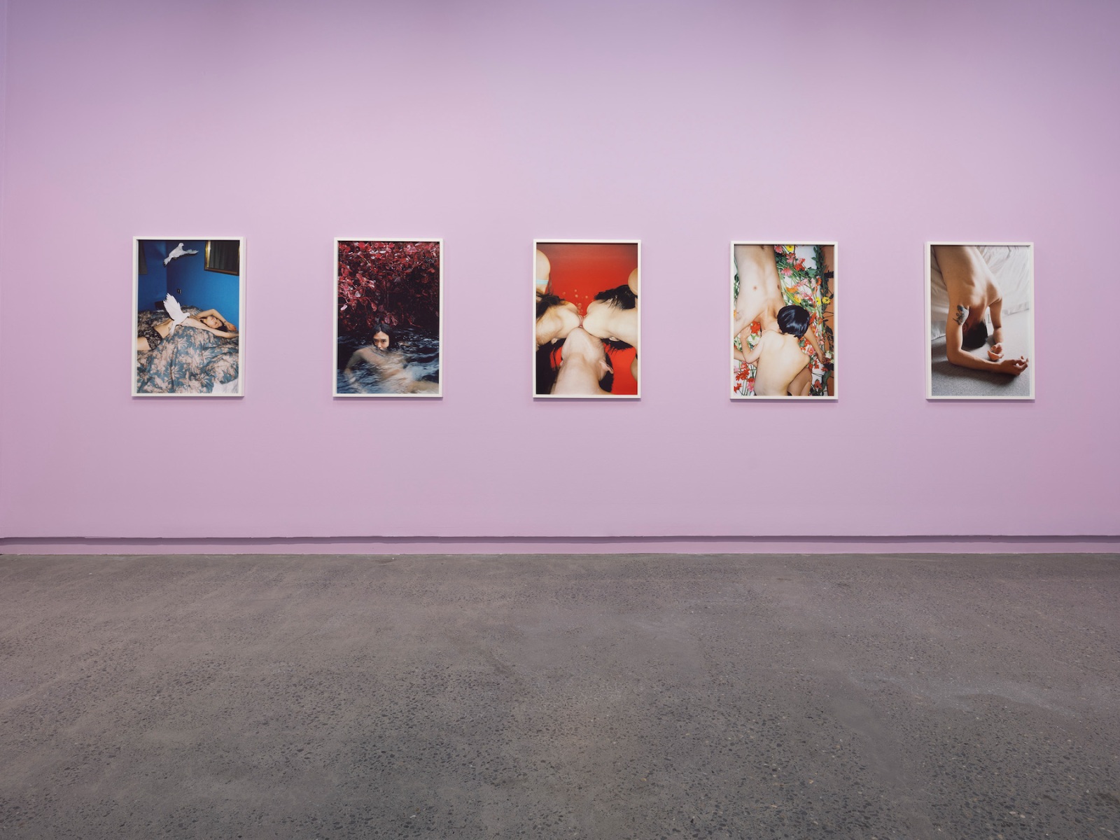 Intimate photographs of Chinese couples and individuals hang on lilac-gallery walls