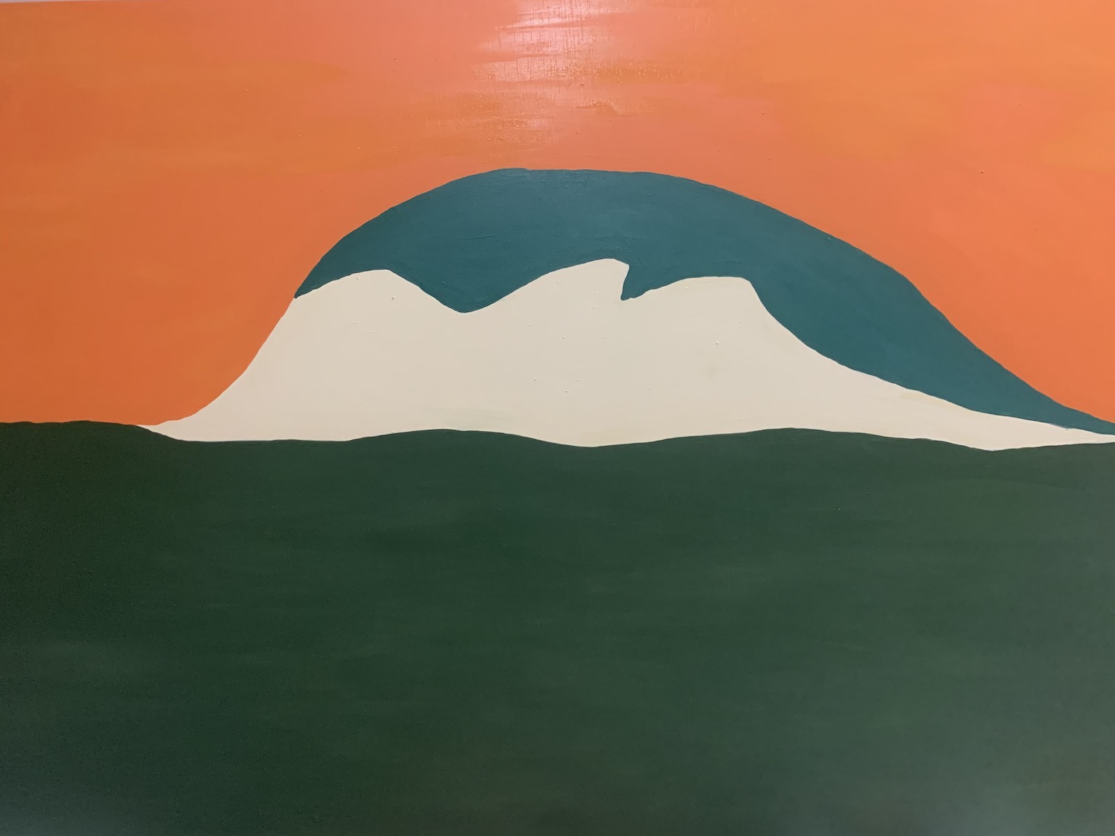 A simple mountain rises out of a green landscape against a bright orange sky