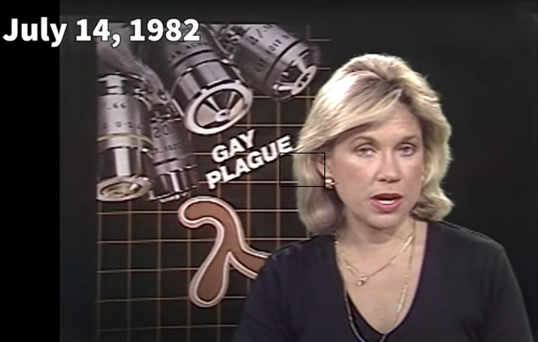 A screengrab of a 1982 Fox TV News segment covering the AIDS Epidemic. A white blonde woman in her 30’s with a manicured, slightly wavy bob, black blouse, and gold necklaces is caught mid-speech. Behind her, is the date ‘JULY 14, 1982’ text, the words ‘GAY PLAGUE’, and a backdrop featuring four silver medicinal canisters, a brown medical symbol, and a thin brown grid.