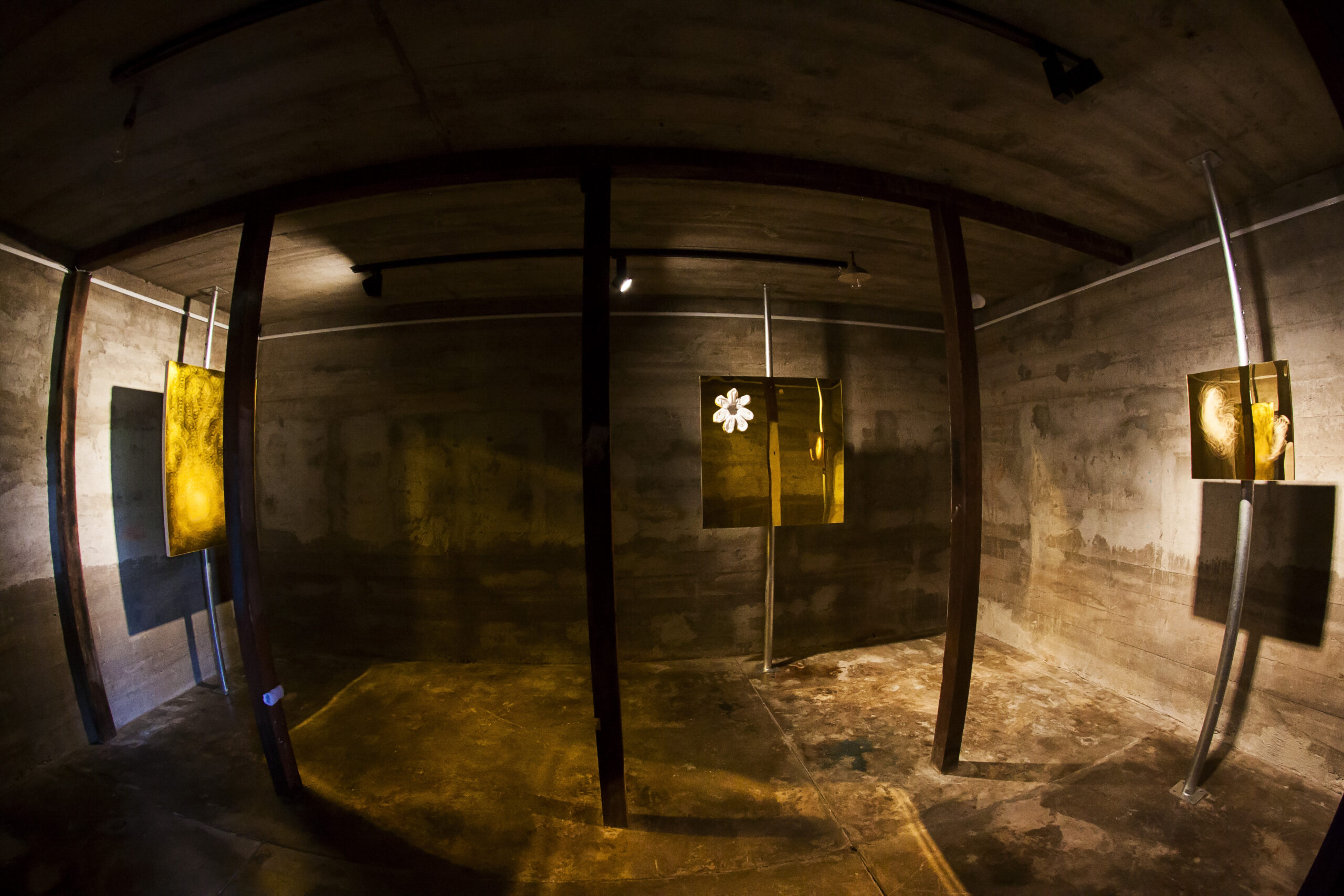 A fish eye lens photo of the bomb shelter room which captures all three installation artworks.