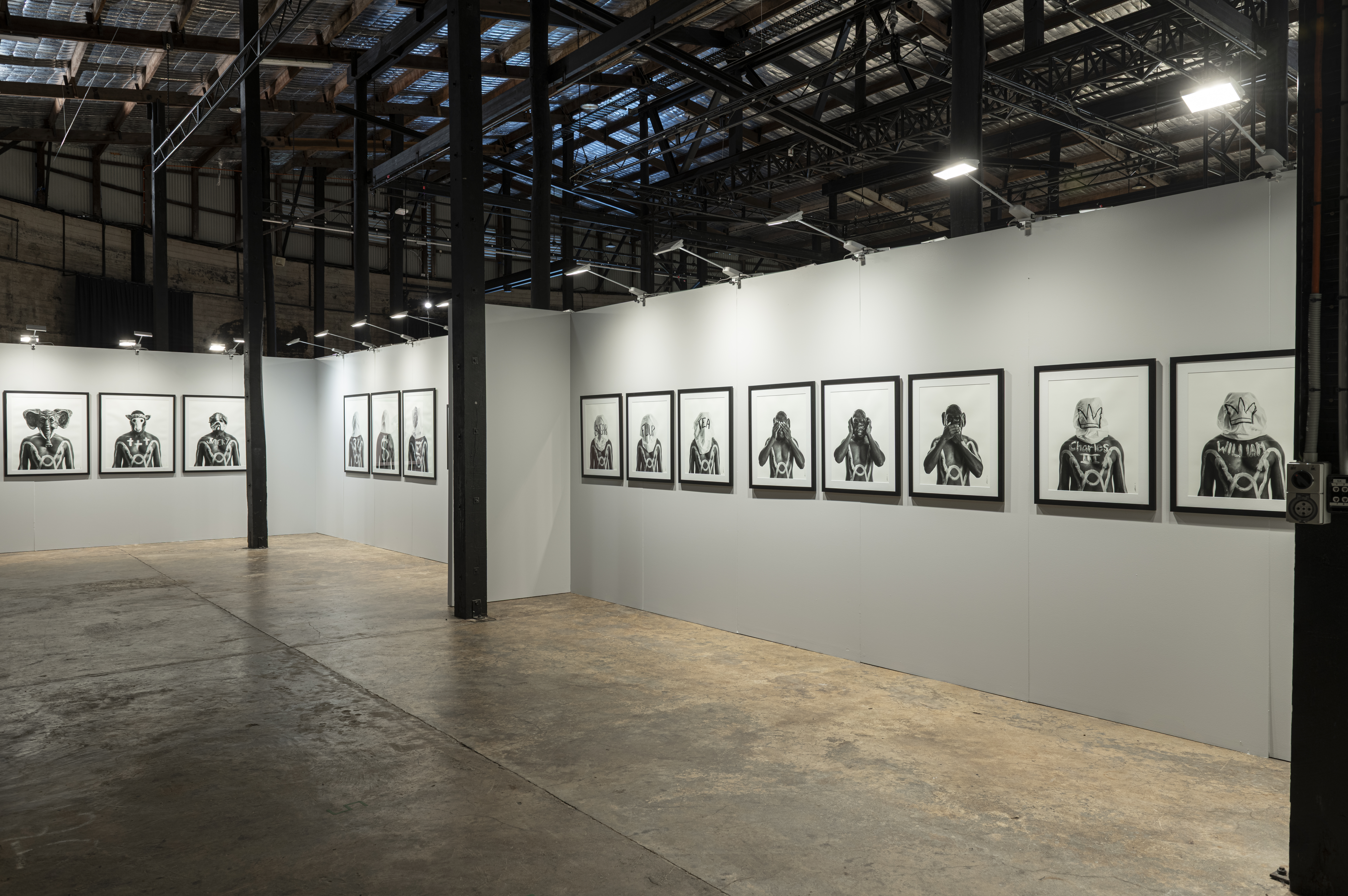 An installation view of the exhibition. Black and white photographs appear on the wall.