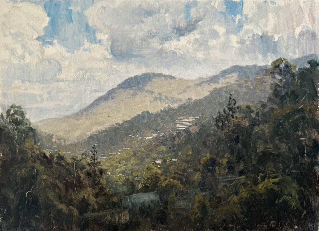 Landscape painting with dark trees in the foreground and pale hills receding under a clouded sky, with heat haze on the rooftops.